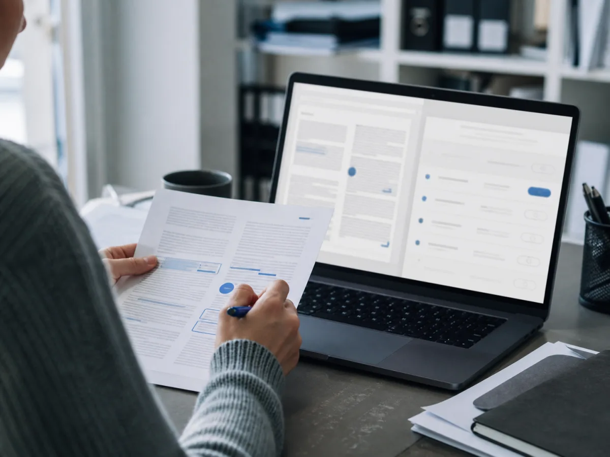 Illustrative scene of a person comparing documents and a computer screen